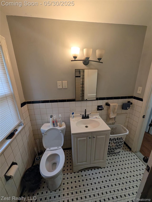 15340 Heyden St, Detroit, MI 48223 - bathroom featuring tile walls, toilet, wainscoting, vanity, and tile patterned flooring
