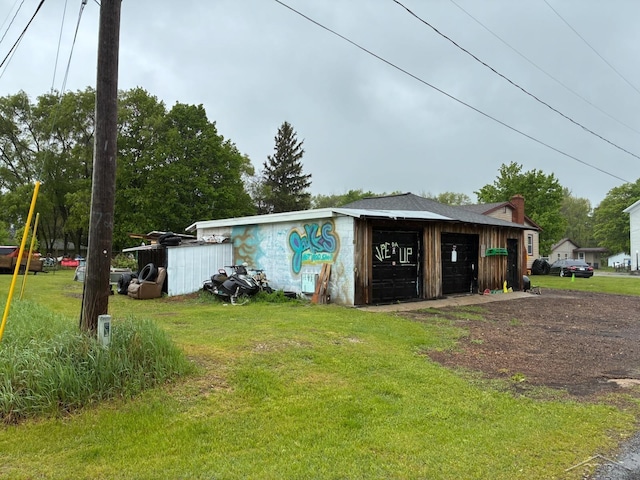 5681 W Fox Rd, Mears, MI 49436 - view of front of property with a front lawn, an outdoor structure, a garage, and driveway