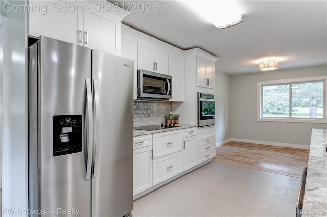 12225 Jeffers Ln, Fenton, MI 48430 - kitchen featuring appliances with stainless steel finishes, white cabinets, decorative backsplash, light stone countertops, and baseboards
