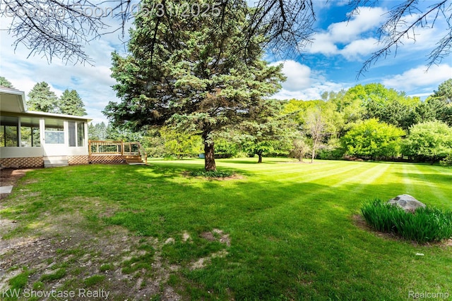 12225 Jeffers Ln, Fenton, MI 48430 - view of green lawn featuring a sunroom and a wooden deck
