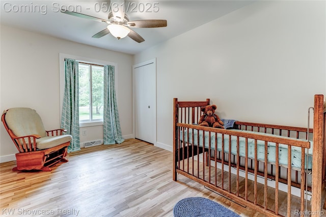 12225 Jeffers Ln, Fenton, MI 48430 - bedroom featuring wood finished floors, baseboards, a closet, a crib, and a ceiling fan