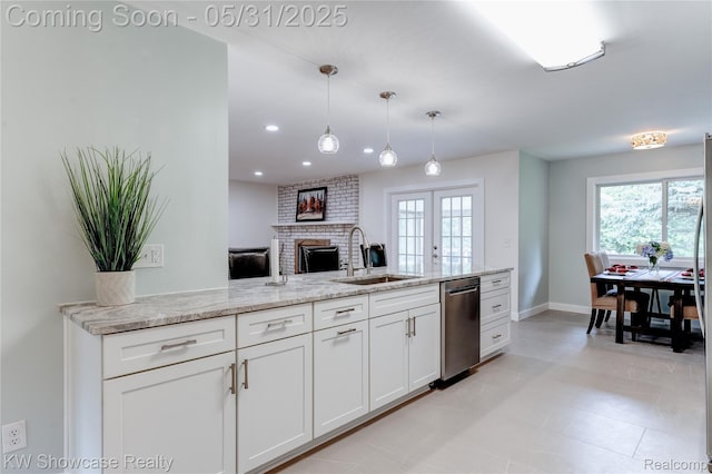 12225 Jeffers Ln, Fenton, MI 48430 - kitchen featuring a sink, stainless steel dishwasher, a fireplace, white cabinets, and baseboards