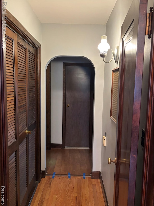 109 W Kennett Rd, Pontiac, MI 48340 - hall with arched walkways, light wood finished floors, and a chandelier