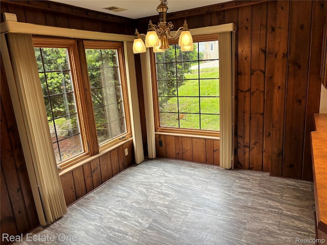 109 W Kennett Rd, Pontiac, MI 48340 - unfurnished dining area with a chandelier, wood walls, and plenty of natural light