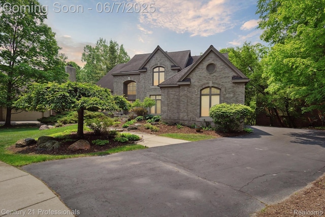 6642 Carlyle Ct, West Bloomfield, MI 48322 - french country style house featuring brick siding, roof with shingles, and a chimney