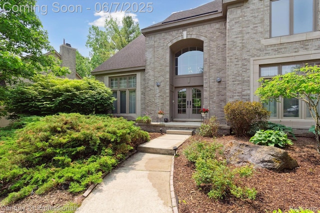 6642 Carlyle Ct, West Bloomfield, MI 48322 - doorway to property featuring french doors, brick siding, and a shingled roof