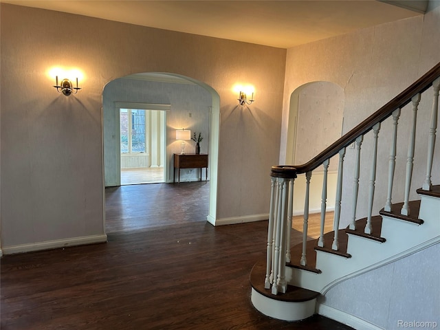 25490 E River Rd, Grosse Ile, MI 48138 - stairs with wood finished floors, baseboards, and arched walkways