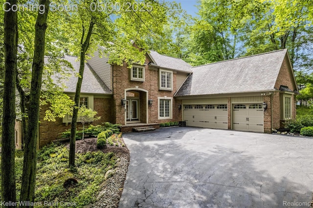 3120 Pond Rd, Leonard, MI 48367 - view of front of house featuring driveway, a garage, roof with shingles, and brick siding