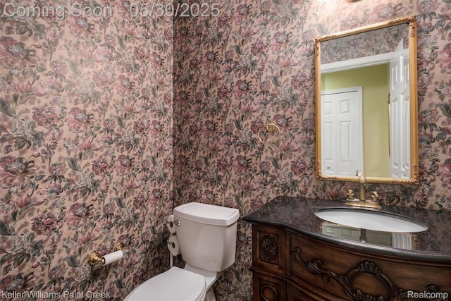 3120 Pond Rd, Leonard, MI 48367 - bathroom with wallpapered walls, toilet, and vanity