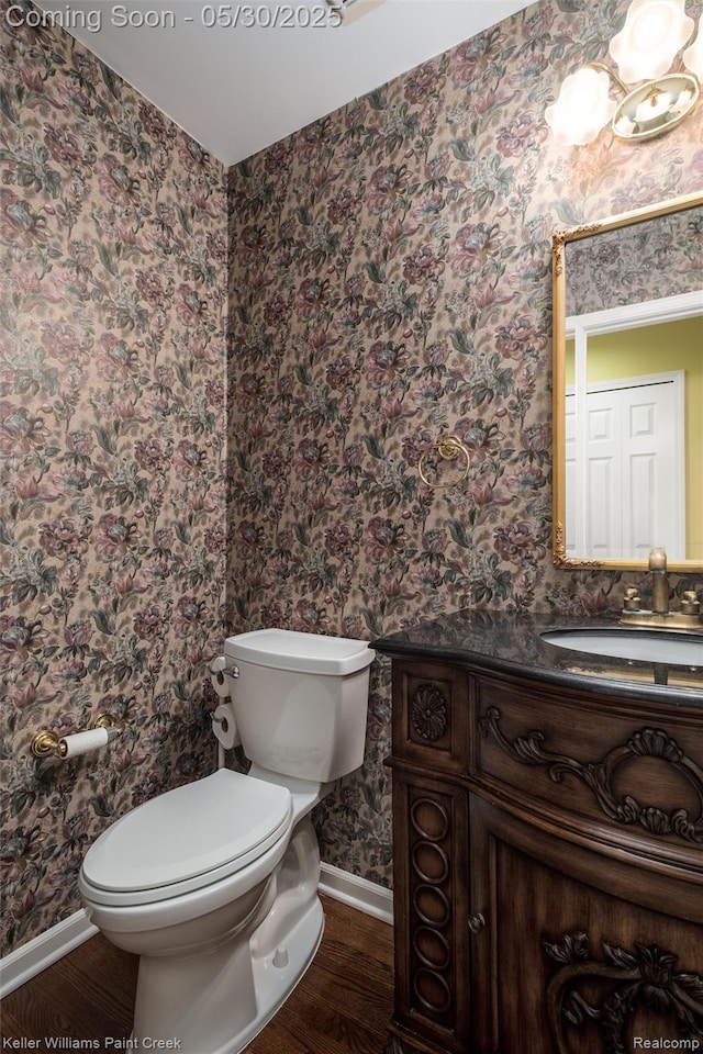 3120 Pond Rd, Leonard, MI 48367 - half bath with wood finished floors, toilet, baseboards, vanity, and wallpapered walls