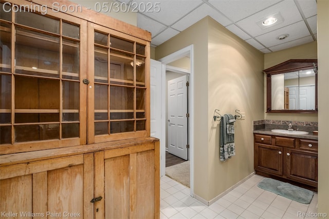 3120 Pond Rd, Leonard, MI 48367 - bathroom featuring vanity, tile patterned floors, a paneled ceiling, and baseboards
