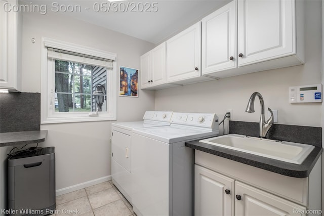 3120 Pond Rd, Leonard, MI 48367 - laundry room with washing machine and dryer, cabinet space, baseboards, and light tile patterned flooring