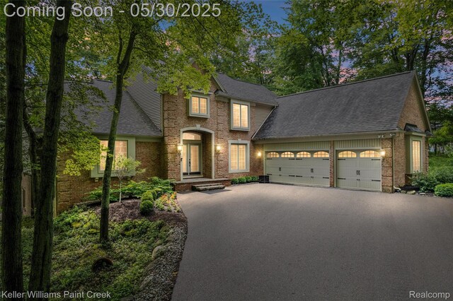 3120 Pond Rd, Leonard, MI 48367 - traditional-style house with asphalt driveway, a garage, brick siding, and roof with shingles