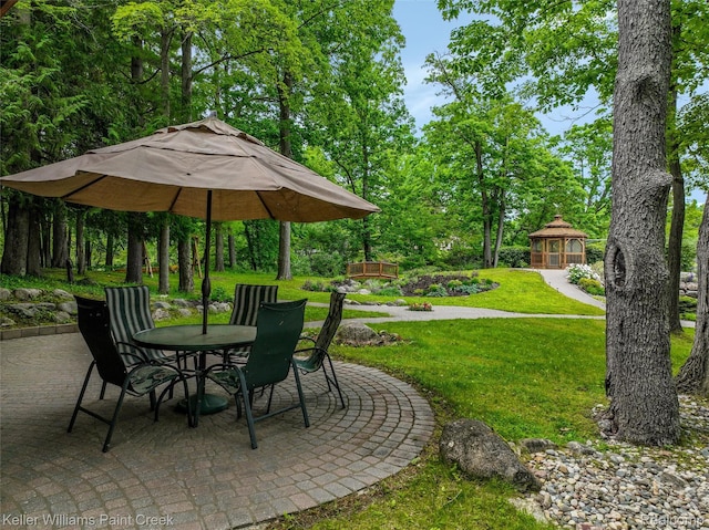 3120 Pond Rd, Leonard, MI 48367 - view of patio with outdoor dining area, a gazebo, and view of wooded area