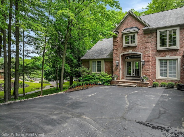 3120 Pond Rd, Leonard, MI 48367 - view of front of property featuring brick siding, french doors, and a shingled roof