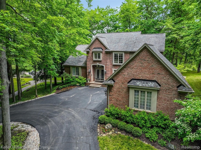 3120 Pond Rd, Leonard, MI 48367 - view of front of home with driveway, brick siding, and a shingled roof