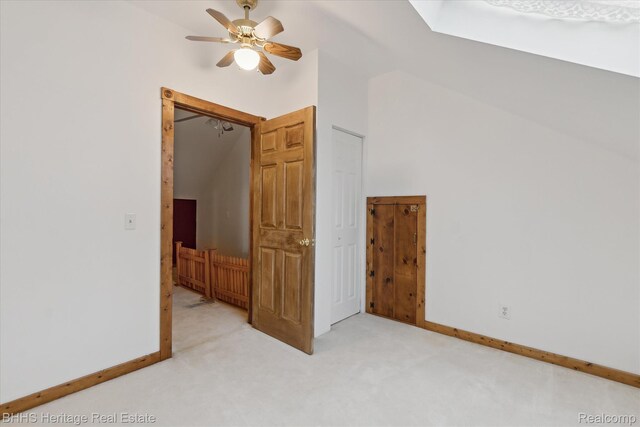301 N Church St, Byron, MI 48418 - unfurnished bedroom featuring light carpet, vaulted ceiling, baseboards, and a ceiling fan