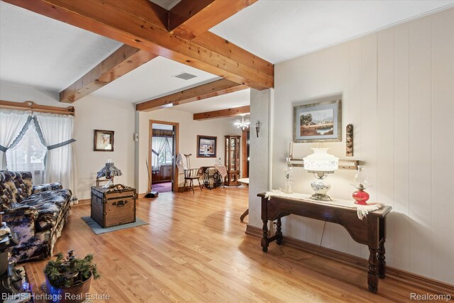 301 N Church St, Byron, MI 48418 - living room with wood finished floors, beam ceiling, and a chandelier