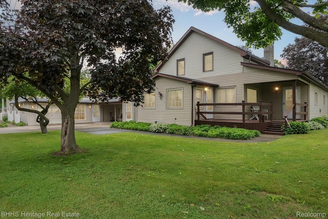301 N Church St, Byron, MI 48418 - view of front of property featuring a front lawn, a chimney, a wooden deck, and driveway