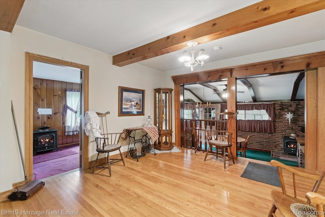 301 N Church St, Byron, MI 48418 - living area featuring a wood stove, wood finished floors, plenty of natural light, and beamed ceiling