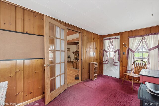 301 N Church St, Byron, MI 48418 - carpeted foyer with wooden walls and french doors