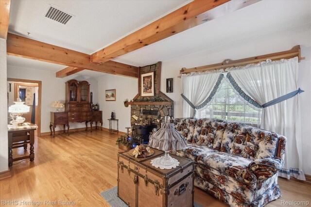 301 N Church St, Byron, MI 48418 - living room with beamed ceiling, light wood-style flooring, baseboards, and a fireplace