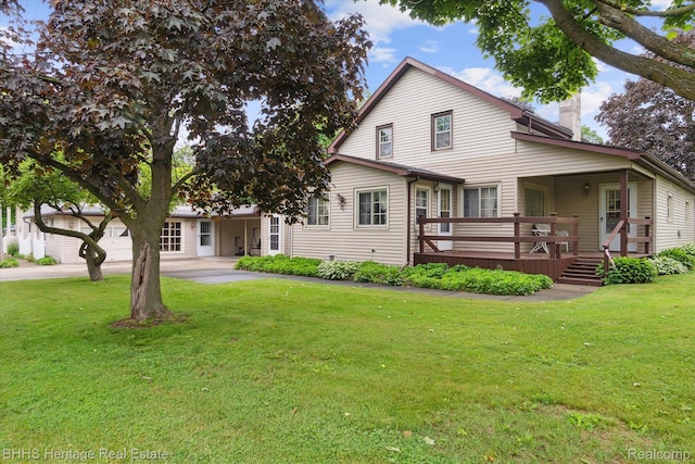 301 N Church St, Byron, MI 48418 - view of front of house with a chimney, a wooden deck, a front lawn, and driveway