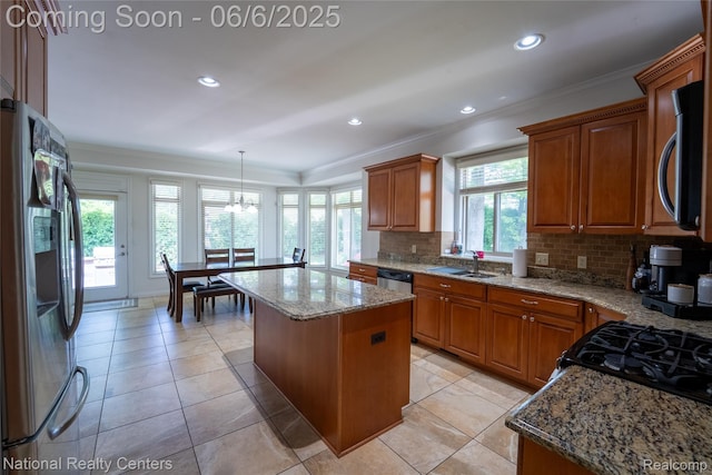 54959 Glen Oaks Dr, Shelby Twp, MI 48315 - kitchen featuring appliances with stainless steel finishes, crown molding, decorative backsplash, a kitchen island, and light stone countertops