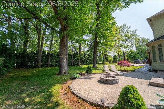 54959 Glen Oaks Dr, Shelby Twp, MI 48315 - view of green lawn featuring an outdoor fire pit and a patio area
