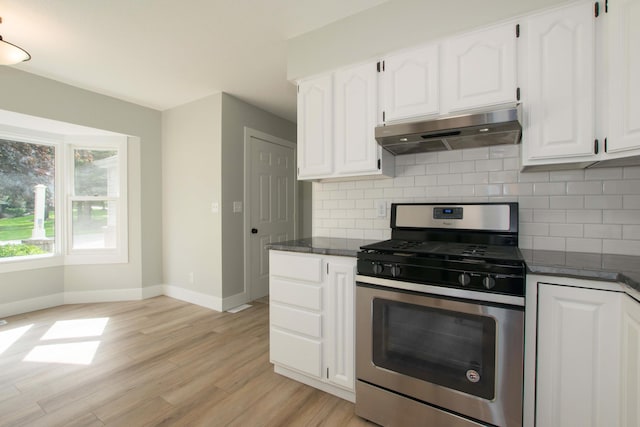 81 Skyline Cir NW, Grand Rapids, MI 49504 - kitchen featuring stainless steel range with gas cooktop, under cabinet range hood, dark countertops, baseboards, and light wood-style floors