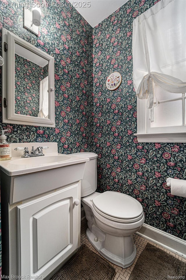 1312 Catalpa Dr, Royal Oak, MI 48067 - bathroom with wallpapered walls, toilet, vanity, tile patterned flooring, and baseboards