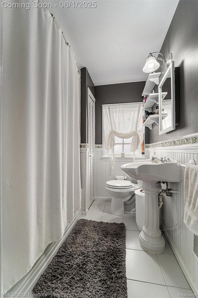 1312 Catalpa Dr, Royal Oak, MI 48067 - full bathroom featuring toilet, wainscoting, tile patterned floors, and a shower with shower curtain
