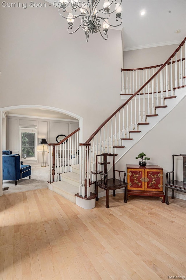 846 Majestic, Rochester, MI 48306 - staircase featuring a chandelier, crown molding, arched walkways, wood finished floors, and a towering ceiling