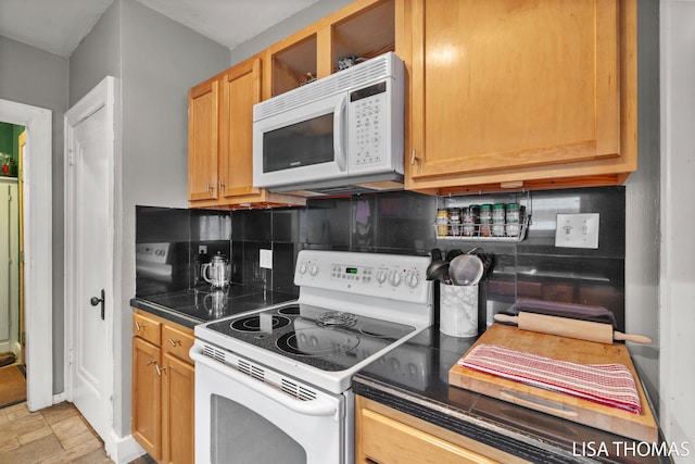 639 College Ave NE, Grand Rapids, MI 49503 - kitchen featuring white appliances, dark countertops, and decorative backsplash