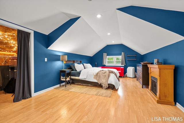 639 College Ave NE, Grand Rapids, MI 49503 - bedroom with wood finished floors, lofted ceiling, baseboards, and a fireplace