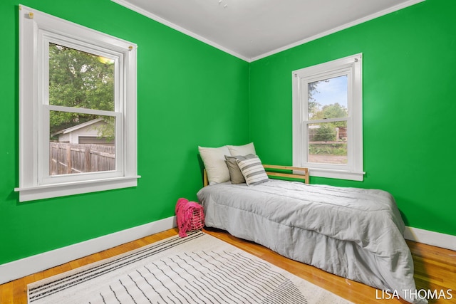639 College Ave NE, Grand Rapids, MI 49503 - bedroom with baseboards, crown molding, and wood finished floors