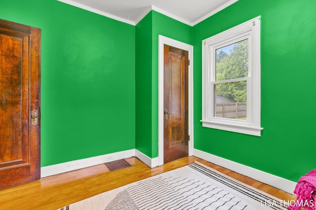 639 College Ave NE, Grand Rapids, MI 49503 - bedroom with baseboards, wood finished floors, and ornamental molding
