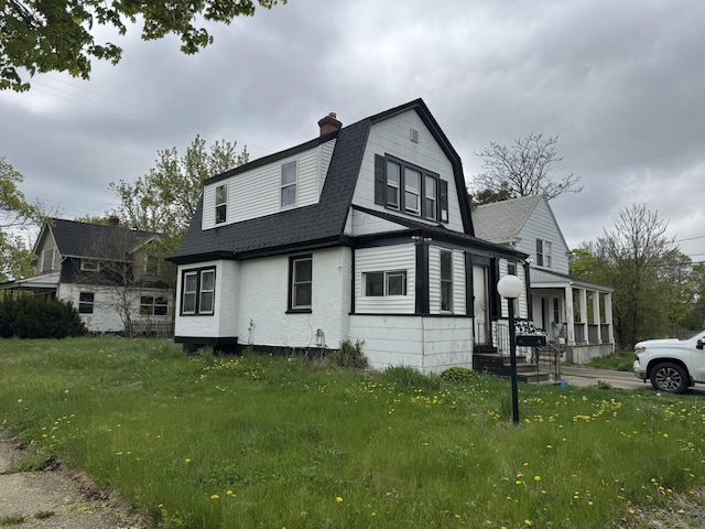 1101 W Rankin St, Flint, MI 48504 - view of side of property with a gambrel roof, a chimney, roof with shingles, and a lawn