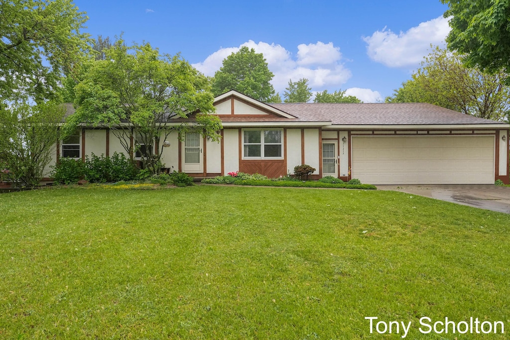 11317 Prairie Ave, Allendale, MI 49401 - ranch-style home with a garage, driveway, a front lawn, and stucco siding
