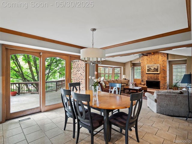 1552 Pebble Creek Dr, Rochester, MI 48307 - dining area featuring a chandelier, lofted ceiling, a brick fireplace, and light tile patterned flooring