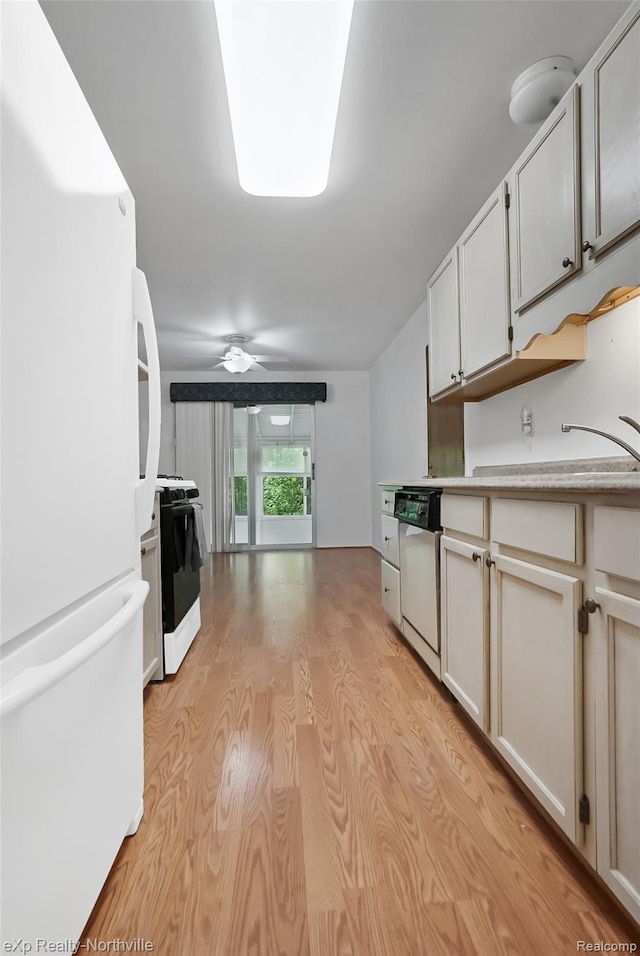 37923 Howell St, Livonia, MI 48154 - kitchen with white appliances, light wood-style flooring, light countertops, ceiling fan, and a sink