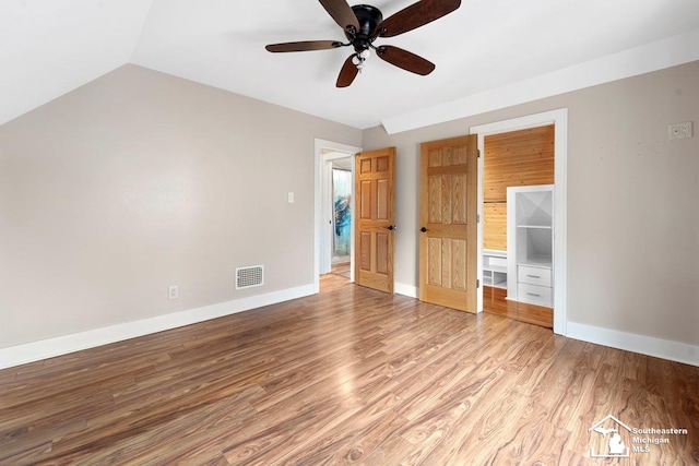 2011 5th St, Wyandotte, MI 48192 - unfurnished bedroom featuring light wood-style flooring, baseboards, ceiling fan, and vaulted ceiling
