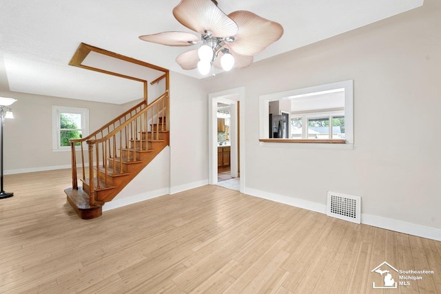 2011 5th St, Wyandotte, MI 48192 - unfurnished living room with wood finished floors, stairway, baseboards, and ceiling fan
