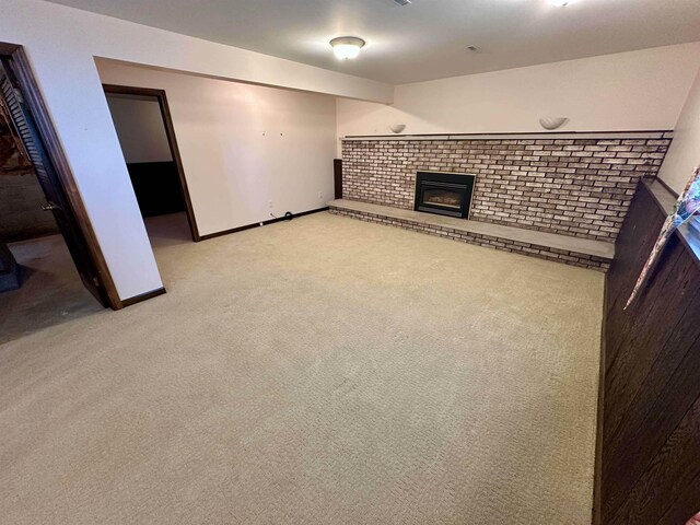 19379 Lincoln Rd, New Lothrop, MI 48460 - unfurnished living room featuring a brick fireplace, light carpet, and baseboards