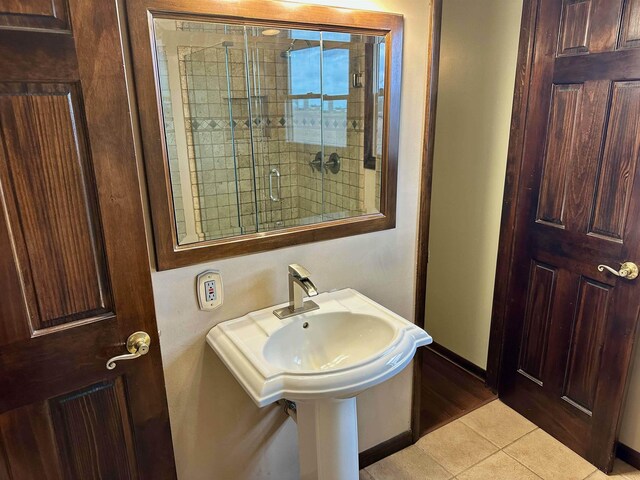 19379 Lincoln Rd, New Lothrop, MI 48460 - full bath with tile patterned floors, baseboards, and a shower with shower door