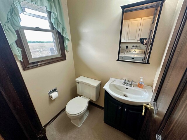 19379 Lincoln Rd, New Lothrop, MI 48460 - half bathroom with toilet, vanity, baseboards, and washer / clothes dryer