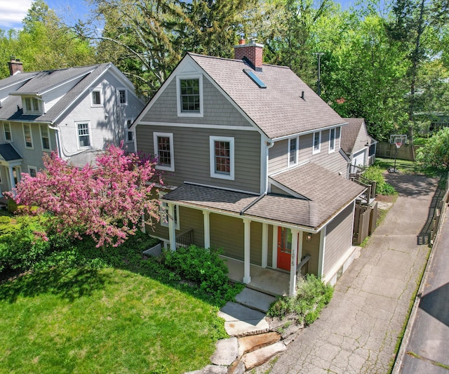 1015 Lincoln Ave, Ann Arbor, MI 48104 - view of front of property featuring a porch, a chimney, a shingled roof, a front lawn, and asphalt driveway