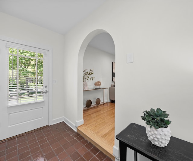 1015 Lincoln Ave, Ann Arbor, MI 48104 - doorway to outside featuring healthy amount of natural light, dark tile patterned floors, baseboards, and arched walkways