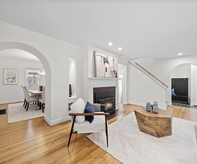 1015 Lincoln Ave, Ann Arbor, MI 48104 - living area with arched walkways, wood finished floors, stairs, a wood stove, and recessed lighting