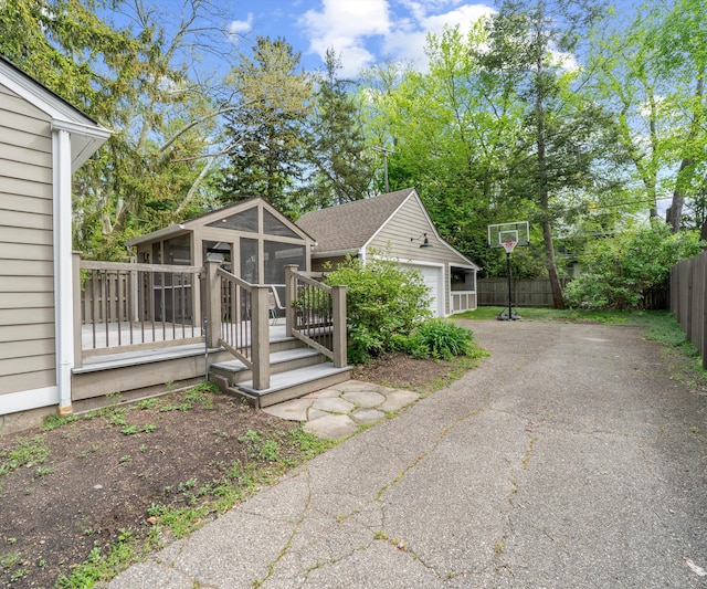 1015 Lincoln Ave, Ann Arbor, MI 48104 - view of home's exterior with a sunroom, an outdoor structure, and a shingled roof